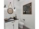 Charming powder room with shiplap walls, a black countertop, and a round mirror with rope detail at 16315 Lonely Ln, Odessa, FL 33556