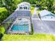 Stunning aerial view of a home with a screened-in pool, a guesthouse, and a spacious driveway at 16603 Hutchison Rd, Odessa, FL 33556