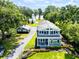 Beautiful two-story home with a manicured lawn, garden beds, and a long driveway at 16603 Hutchison Rd, Odessa, FL 33556