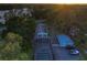 Aerial shot of a home featuring a screened pool, a guesthouse, and multiple vehicles parked in the driveway at 16603 Hutchison Rd, Odessa, FL 33556