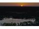Scenic aerial view of lake with homes nestled among trees and a breathtaking sunset at 16603 Hutchison Rd, Odessa, FL 33556