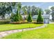 Well-manicured backyard featuring lush lawn, ornamental trees and brick paver pathway at 16603 Hutchison Rd, Odessa, FL 33556
