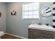 A cozy bathroom featuring a vanity with modern finishes and a nautical themed mirror and art at 16603 Hutchison Rd, Odessa, FL 33556