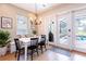 Cozy dining area with natural light, a modern chandelier, and access to the outdoor space at 16603 Hutchison Rd, Odessa, FL 33556