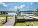 A wooden dock and gazebo on a lake with boat and kayak storage at 16603 Hutchison Rd, Odessa, FL 33556
