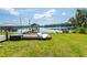 Lake with gazebo and dock featuring kayak and boat storage areas on the grassy shore at 16603 Hutchison Rd, Odessa, FL 33556