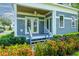 Inviting front porch with double doors, wood ceiling and lush landscaping, creating an attractive entry at 16603 Hutchison Rd, Odessa, FL 33556