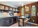 Kitchenette offers dark cabinetry, a breakfast bar, stainless steel refrigerator, and white backsplash at 16603 Hutchison Rd, Odessa, FL 33556