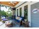 Inviting covered porch features comfortable furniture, ceiling fan, and outdoor TV at 16603 Hutchison Rd, Odessa, FL 33556