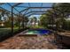 Inviting screened-in pool and spa with elegant brick paving and landscape, perfect for outdoor relaxation at 16603 Hutchison Rd, Odessa, FL 33556