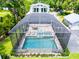 Aerial view of a screened-in pool and patio area with seating and lounge chairs at 16603 Hutchison Rd, Odessa, FL 33556