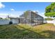 Large backyard features a screened pool, grass, and a privacy fence at 1700 Ironwood E Ct, Oldsmar, FL 34677