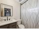 Bathroom with vanity, framed mirror, toilet, and decorative shower curtain at 1700 Ironwood E Ct, Oldsmar, FL 34677