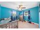 Cozy bedroom features bright blue walls, neutral floors, and a ceiling fan at 1700 Ironwood E Ct, Oldsmar, FL 34677