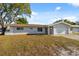 Charming home with manicured lawn, attached garage, and inviting front entrance at 1700 Ironwood E Ct, Oldsmar, FL 34677
