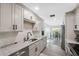 Modern renovated kitchen with stainless steel appliances, gray cabinets, and granite countertops at 1700 Ironwood E Ct, Oldsmar, FL 34677