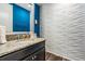 Modern half bath with textured wall, granite counters, and sleek fixtures at 17724 Daisy Farm Dr, Lutz, FL 33559