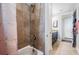 Bathroom with a tiled bathtub and shower, modern fixtures, and a view into the adjacent bathroom area at 17724 Daisy Farm Dr, Lutz, FL 33559