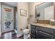 Bathroom featuring a vanity with granite countertop, mirror, and walk-in shower beyond the toilet at 17724 Daisy Farm Dr, Lutz, FL 33559