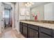 Bathroom featuring double sinks with granite countertops, dark cabinets, and modern fixtures at 17724 Daisy Farm Dr, Lutz, FL 33559