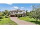 Elegant two-story home with three-car garage, stone accents, balcony and manicured lawn at 17724 Daisy Farm Dr, Lutz, FL 33559