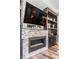 Close-up of the modern fireplace with stone surround and built-in shelving and cabinets at 17724 Daisy Farm Dr, Lutz, FL 33559
