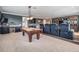 Entertaining game room featuring a pool table, wet bar, theatre chairs, and large built-in shelving unit for a modern feel at 17724 Daisy Farm Dr, Lutz, FL 33559
