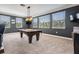 Spacious game room with a pool table, neutral carpet, and large windows that offer natural light and outdoor views at 17724 Daisy Farm Dr, Lutz, FL 33559