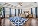 Bright main bedroom with tray ceiling, wood floors, and a large blue patterned rug at 17724 Daisy Farm Dr, Lutz, FL 33559
