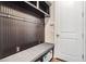 Stylish mudroom features a bench with storage and dark wood paneling with hooks at 17724 Daisy Farm Dr, Lutz, FL 33559