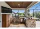 Outdoor kitchen featuring a built-in grill, granite countertops, and wood-paneled ceiling at 17724 Daisy Farm Dr, Lutz, FL 33559