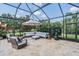 Stylish outdoor seating area with comfortable couches, an umbrella, and a serene backyard view at 17724 Daisy Farm Dr, Lutz, FL 33559