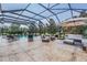 Outdoor patio with a screened pool, lounge furniture, and lush landscaping for relaxing at 17724 Daisy Farm Dr, Lutz, FL 33559