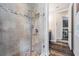 Tiled shower with glass door, river rock floor, and view to the laundry room at 17724 Daisy Farm Dr, Lutz, FL 33559