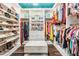 Spacious walk-in closet with ample shelving, hanging space, drawers, and a central ottoman at 17724 Daisy Farm Dr, Lutz, FL 33559