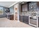 Game room wet bar area with cabinets, tiled backsplash, sink, and beverage cooler at 17724 Daisy Farm Dr, Lutz, FL 33559