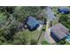 Aerial view of the house with a long driveway and a detached garage at 1820 Rumar Ln, Holiday, FL 34691
