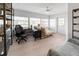 Bright bonus room with multiple windows, versatile futon, and sleek black desk, perfect for relaxing and home office use at 1820 Rumar Ln, Holiday, FL 34691