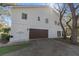View of home's exterior with a large garage, manicured lawn and mature trees at 1820 Rumar Ln, Holiday, FL 34691