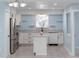 Updated kitchen boasts stainless steel appliances, white cabinets, and a center island with a marble countertop at 1820 Rumar Ln, Holiday, FL 34691