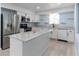 Updated kitchen boasts stainless steel appliances, white cabinets, and a center island with a marble countertop at 1820 Rumar Ln, Holiday, FL 34691