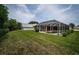 Expansive backyard with verdant lawn and screened-in pool, perfect for outdoor entertaining and relaxation at 2143 Edelweiss Loop, Trinity, FL 34655
