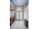 Bright foyer with high ceilings, tile flooring, and decorative glass front doors at 2143 Edelweiss Loop, Trinity, FL 34655