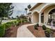 Inviting covered front porch with arched entryway and decorative landscaping at 2143 Edelweiss Loop, Trinity, FL 34655
