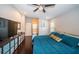 Comfortable main bedroom with hardwood floors, ceiling fan, television, and ensuite bathroom at 2143 Edelweiss Loop, Trinity, FL 34655