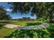 Scenic view of a community playground with slides and swings, framed by lush green grass and mature trees at 2143 Edelweiss Loop, Trinity, FL 34655