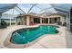 Screened pool area features a kidney-shaped pool and attached covered patio, with ample space to relax at 2143 Edelweiss Loop, Trinity, FL 34655