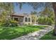 Charming home featuring a stucco exterior, arched windows, tile roof, and lush landscaping on a sunny day at 2511 W Morrison Ave, Tampa, FL 33629