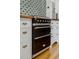 Close-up of a black oven with brass trim set between white cabinets and drawers at 2511 W Morrison Ave, Tampa, FL 33629
