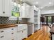 Bright kitchen featuring white cabinets, wood countertops, colorful backsplash, and stainless steel appliances at 2511 W Morrison Ave, Tampa, FL 33629